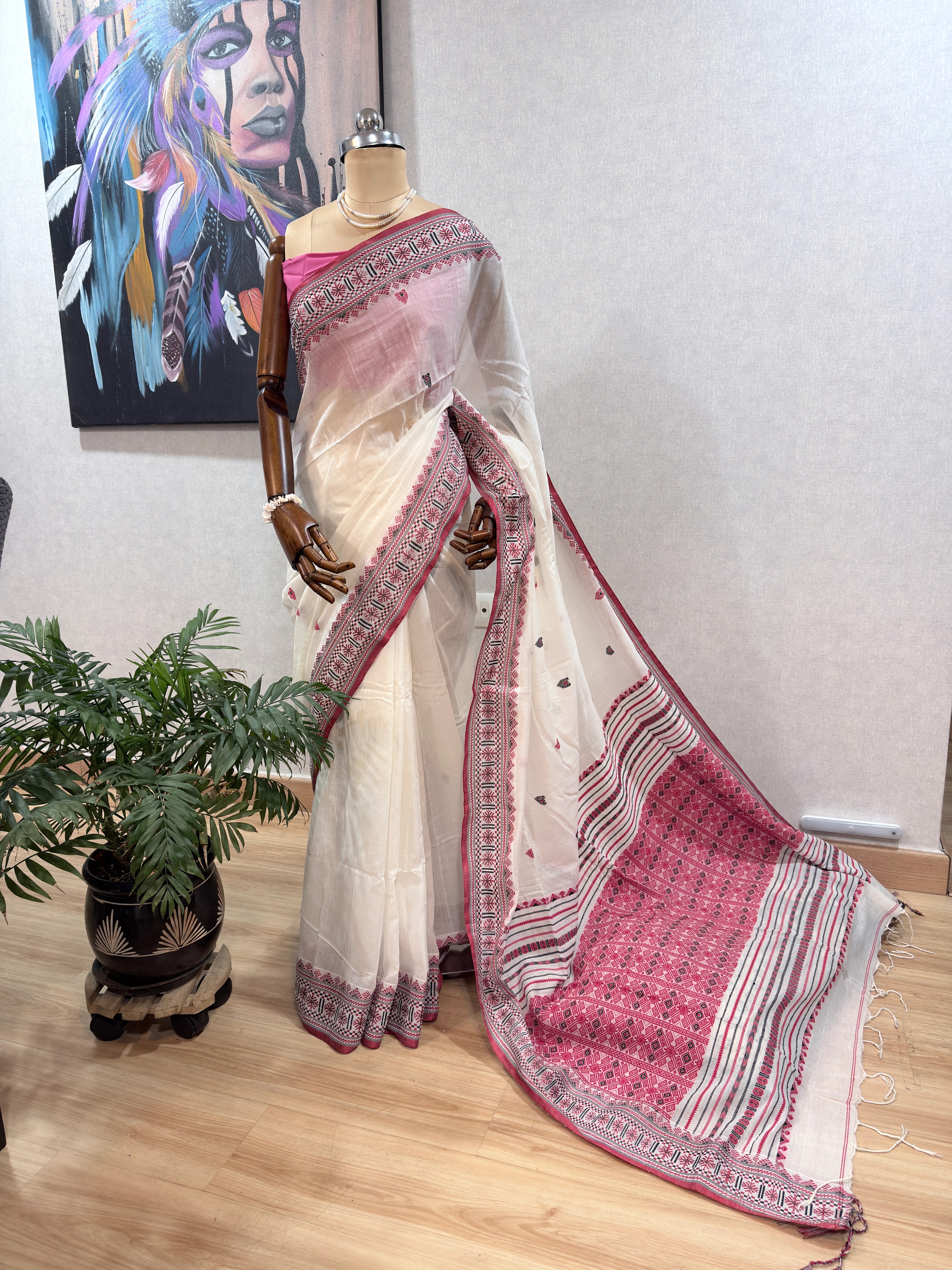 Dhonekhali cotton saree on the mannequin, closer view of the pallu drape with pink geometric border against the cream body.